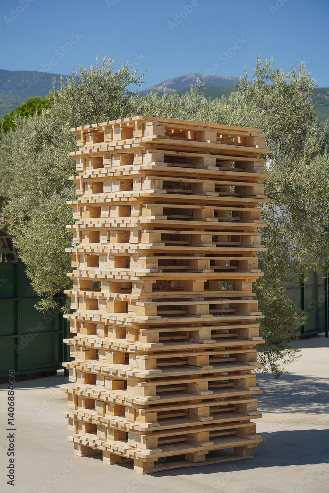 Large pile of wooden pallets outdoors at the factory loading dock.