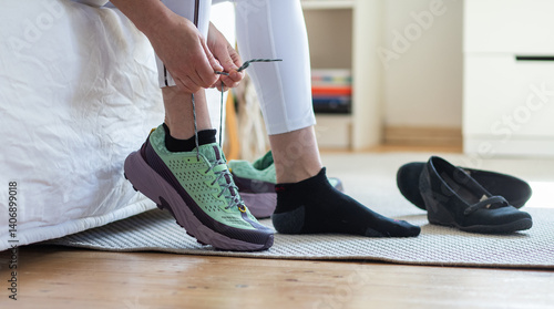 Fotografija fit woman at home taking her running shoes getting ready for a run