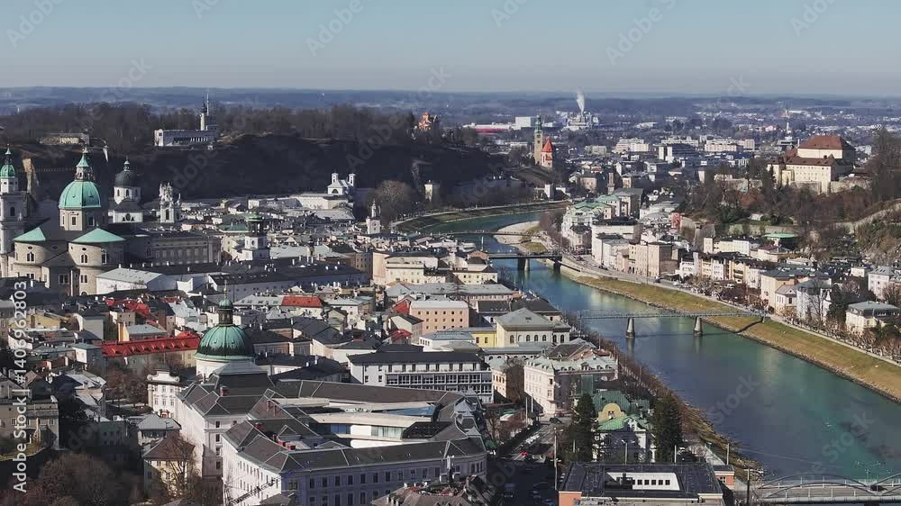 Aerial view of Salzburg, Austria, featuring the Salzach River, Salzburg Cathedral, Hohensalzburg Fortress, and surrounding mountains with camera panning. Aerial view of Salzburg, Austria, featuring the Salzach River, Salzburg Cathedral, Hohensalzburg Fortress, and surrounding mountains with camera panning.