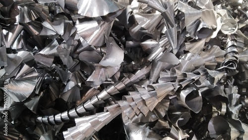 Steel scrap materials recycling. Aluminum chip waste after machining metal parts on a cnc lathe. Closeup twisted spiral steel shavings. Small roughness sharpness,