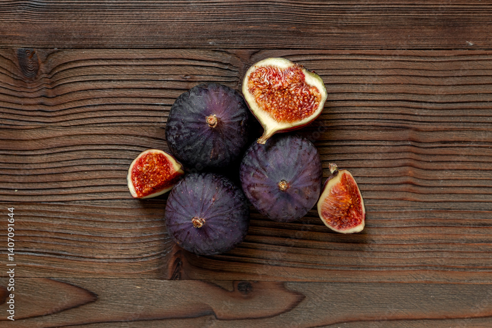 Whole and cut fresh ripe figs on wooden table. Top view Whole and cut fresh ripe figs on wooden table. Top view