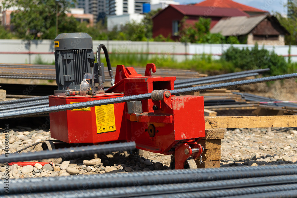 Hydraulic rebar bending machine bending steel bars at a construction site, preparing essential reinforcement for concrete work, ensuring strength and stability in building projects