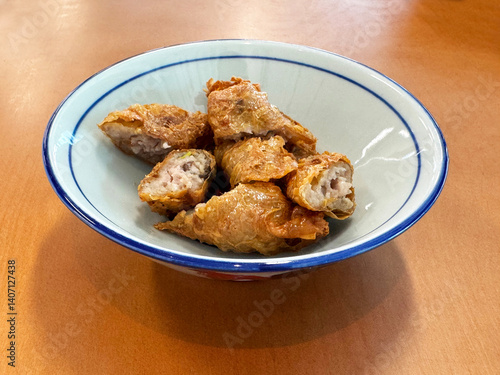 Obraz na płótnie traditional asian deep fried crispy golden chicken wu xiang meat vege roll appetiser in white bowl on wood table chinese dim sum snack cafe halal menu food restaurant w salonie