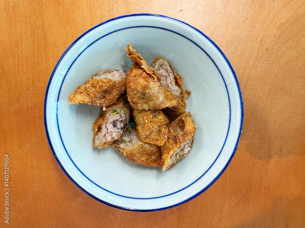 traditional asian deep fried crispy golden chicken wu xiang meat vege roll appetiser in white bowl on wood table chinese dim sum snack cafe halal menu food restaurant