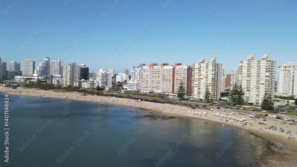 Tourists relaxing on playa mansa beach in punta del este, uruguay, enjoying a beautiful sunny day Tourists relaxing on playa mansa beach in punta del este, uruguay, enjoying a beautiful sunny day