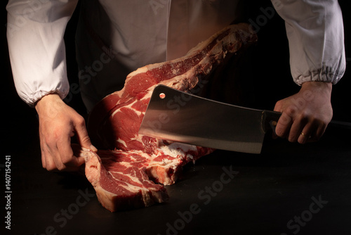 Butcher cutting loin on black background