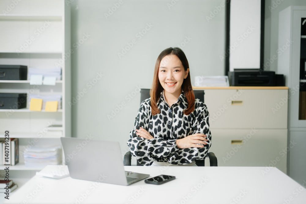Young Asian businesswoman smiling and working with tablet and laptop in office. Young Asian businesswoman smiling and working with tablet and laptop in office.
