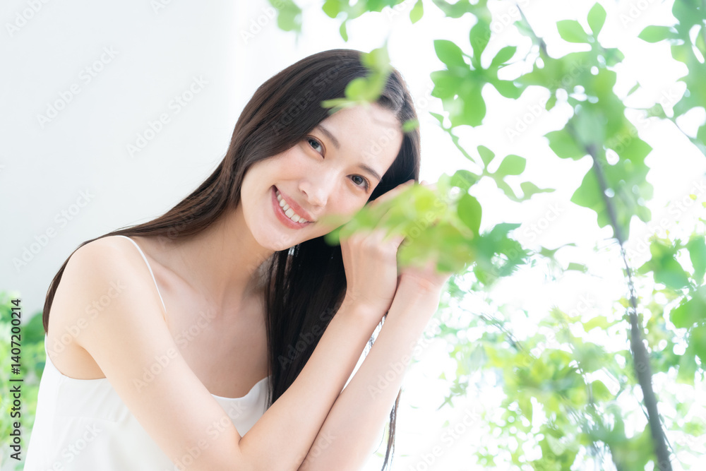 緑の中でスキンケアをする若い女性 緑の中でスキンケアをする若い女性