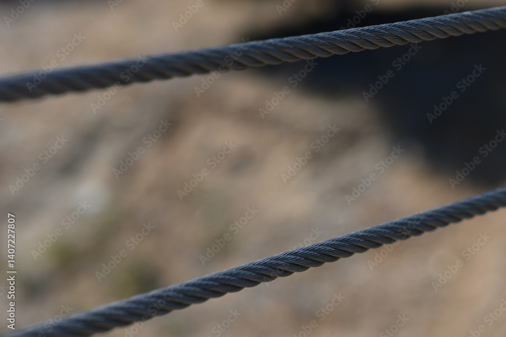 Intricate patterns of twisted cables against a blurred natural backdrop reveal the beauty of everyday structures in outdoor spaces Intricate patterns of twisted cables against a blurred natural backdrop reveal the beauty of everyday structures in outdoor spaces