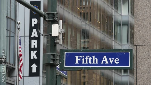 Fifth avenue, 5 ave road sign, Manhattan midtown architecture, New York City 5th av street corner. Traffic crossroad signage, USA. Parking garage and american flag.