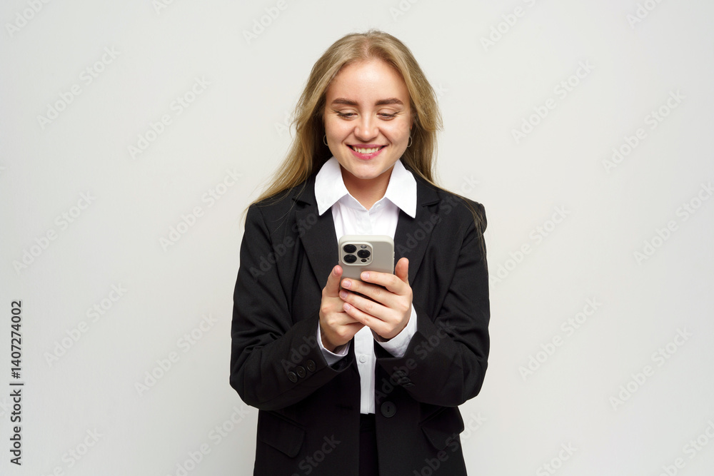 Smiling Woman in Business Attire Engages With Her Smartphone, Showcasing Modern Technology in a Bright Studio Setting Smiling Woman in Business Attire Engages With Her Smartphone, Showcasing Modern Technology in a Bright Studio Setting