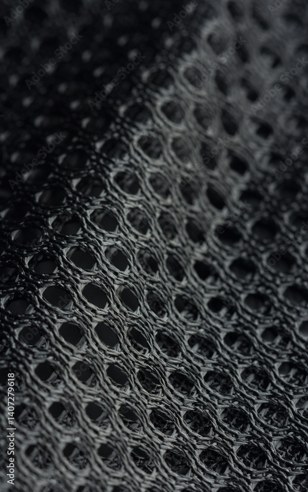 Black mesh fabric with a textured pattern in macro view, commonly used in sportswear, selective focus