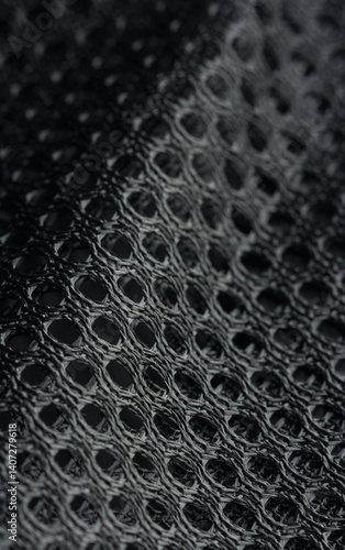 Obraz na płótnie Black mesh fabric with a textured pattern in macro view, commonly used in sportswear, selective focus w salonie