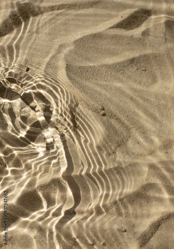 Fototapeta Naklejka Na Ścianę i Meble -  Water texture with shadows on sea beach sand