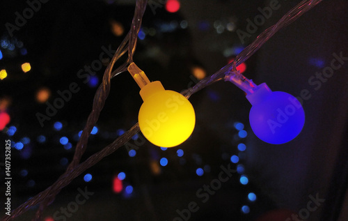 Foto Close-up of vibrant yellow and blue LED lights on a string, creating a festive and modern bokeh effect against a dark background
