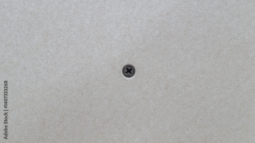 Black screw screwed into drywall close up Black screw screwed into drywall close up