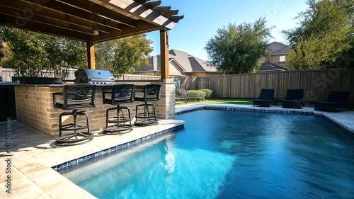 An inviting outdoor entertainment area with a fully stocked bar, a high-end BBQ grill, and black bar stools under a rustic wooden pergola. The sparkling pool adds a touch of tranqu