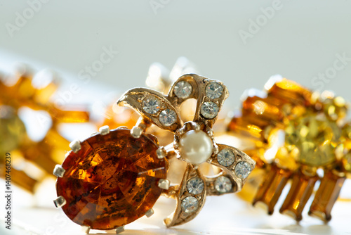 Wallpaper Mural Macro view of vintage costume jewelry faux topaz, pearl and diamonds earring on grey and white background, with other earrings in soft focus background Torontodigital.ca