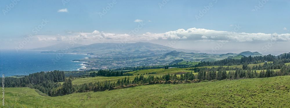 Fototapeta premium Coastal landscape with green hills and distant mountains, Miradouro do Salto do Cavalo, Sao Miguel, Azores, Portugal