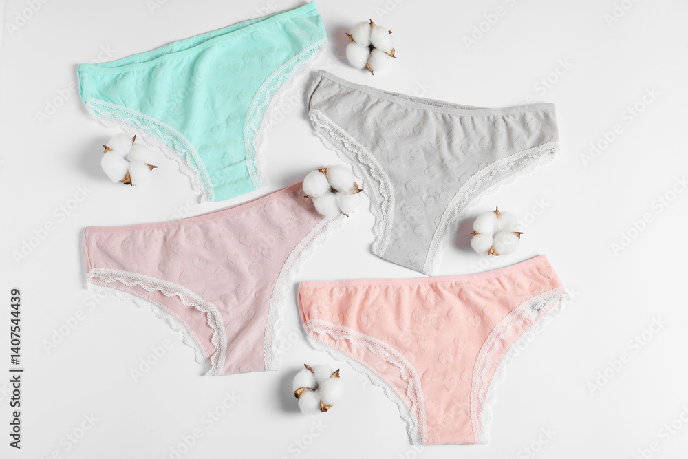 Women's underwear. Beautiful panties and cotton flowers on white background, flat lay