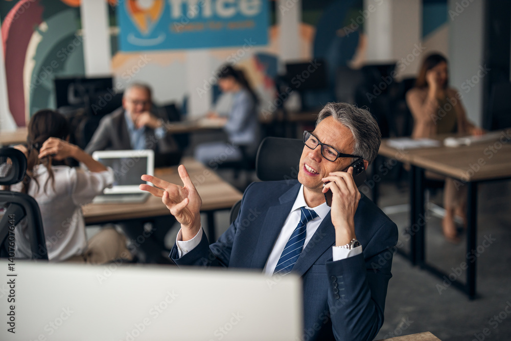 Business Professional Discussing Over Phone in a Collaborative Modern Office Setting