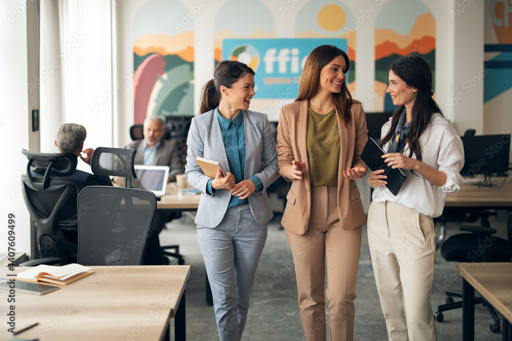 Three Businesswomen Engaged in Casual Conversation in a Modern Office Setting