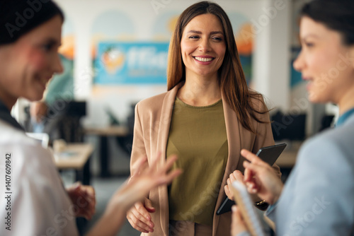 Obraz na płótnie Smiling Businesswoman Engaging in Workplace Interaction with Colleagues w salonie