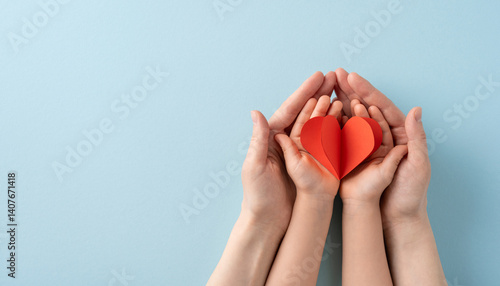 Image depicting adult and child hands holding a red heart, representing love, care, and family bonds