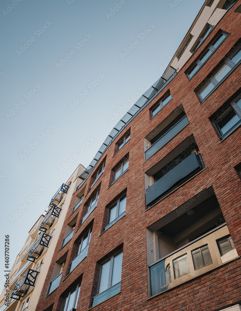 Urban architecture featuring a stylish brick facade on a modern residential apartment building during daylight. Captures the details of city living and contemporary construction. Urban architecture featuring a stylish brick facade on a modern residential apartment building during daylight. Captures the details of city living and contemporary construction.