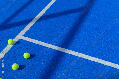 three balls in a padel tennis court blue artificial grass floor near the lines, racket sports background concept