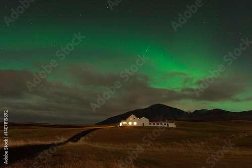 Obraz na płótnie Amazing northern lights with starry sky. Aurora borealis over a lonely house in Iceland w salonie
