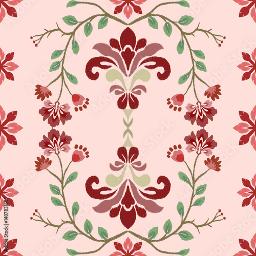 A floral pattern featuring intricate red designs and green foliage on a soft pink background, ideal for textiles or wallpaper.