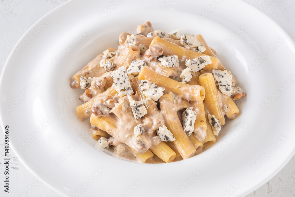 Penne pasta served with creamy walnut blue cheese sauce on white plate Penne pasta served with creamy walnut blue cheese sauce on white plate