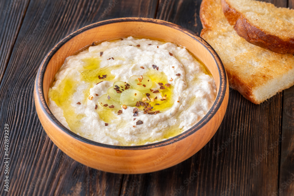 Creamy baba ghanoush in wooden bowl with chili and olive oil Creamy baba ghanoush in wooden bowl with chili and olive oil