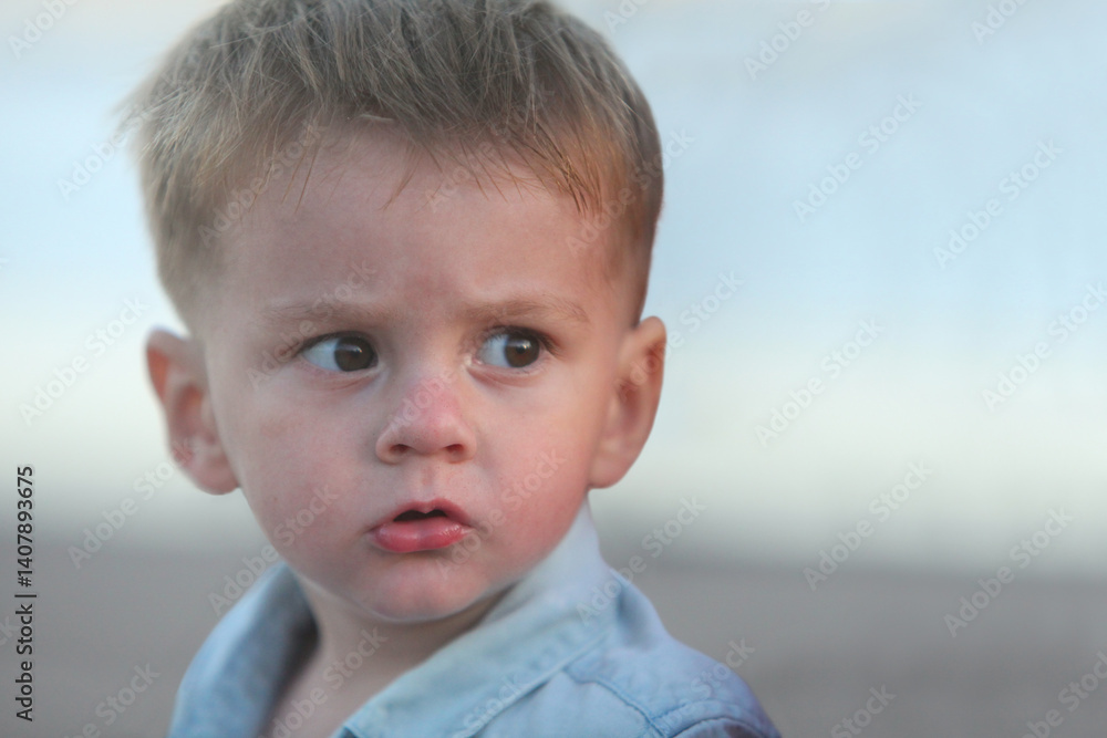 closeup portrait of a cute worried serious little toddler boy outdoors at dusk with ocean in background closeup portrait of a cute worried serious little toddler boy outdoors at dusk with ocean in background