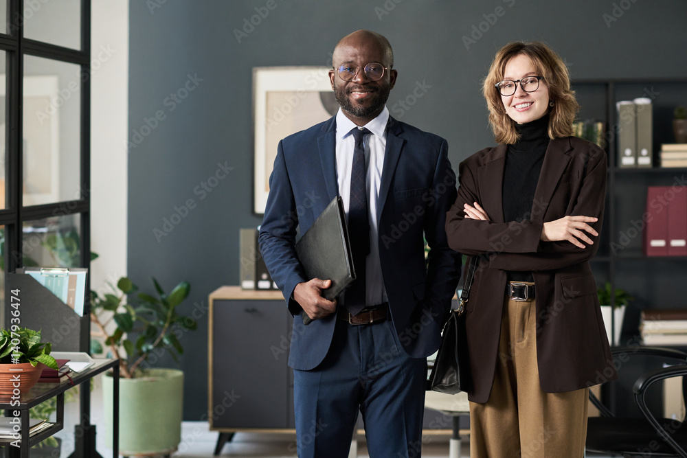 © pressmaster - Portrait of multiethnic business couple smiling at camera while standing in office