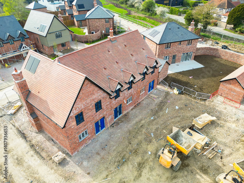 Obraz na płótnie Aerial view of terraced affordable homes seen nearly completed on a British construction site in rural Essex. Seen near expensive, detached executive homes. w salonie