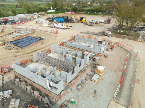 Low level aerial view of a British housing development site in the east of the country. Showing partially built private and smaller, affordable homes. Located in rural Essex.