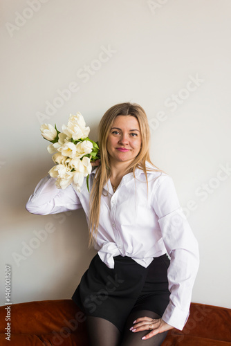 A woman holds white tulips in her hands