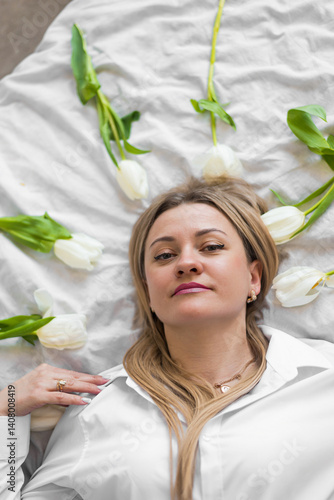 Young woman lying on white bed