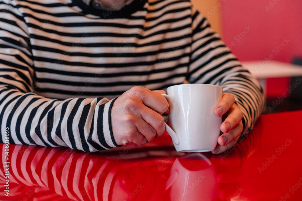 A young man is drinking coffee at a cafe table A young man is drinking coffee at a cafe table