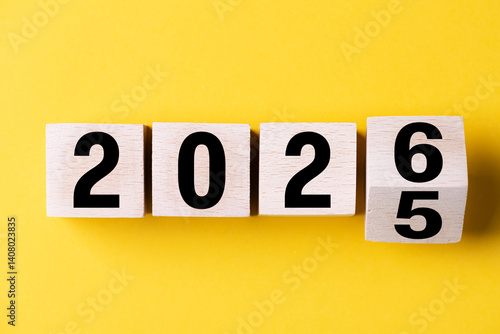2026 Happy New Year. Wooden cube block change from 2025 to 2026 on blue. Concept 2026 New Year background. Business, resolutions, goals, inspiration, success, ideas