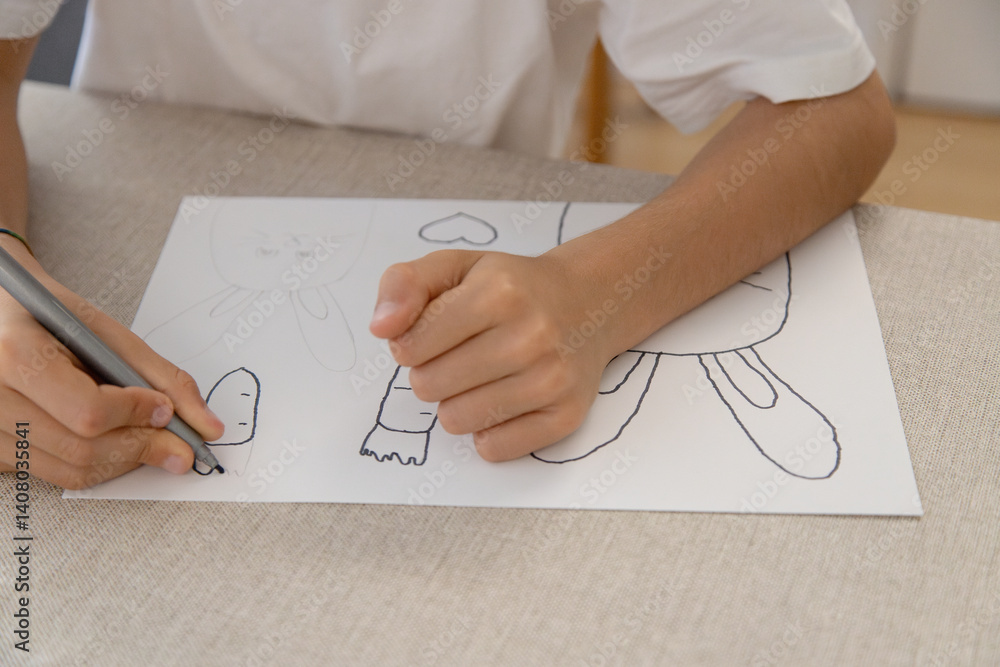 A child traces and colors Easter-themed drawings of bunnies, carrots and hearts during a fun and creative activity at home. Improving fine motor skills. A child traces and colors Easter-themed drawings of bunnies, carrots and hearts during a fun and creative activity at home. Improving fine motor skills.