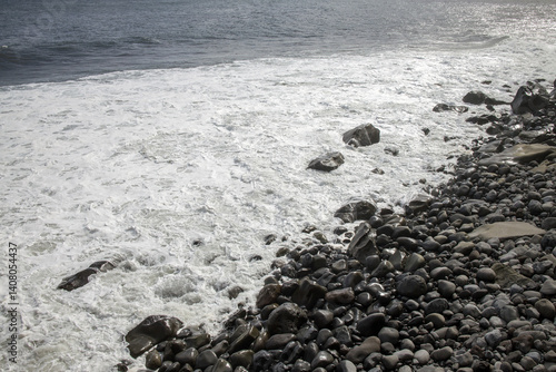 Obraz na płótnie Waves crash against rocky shore at Madeira during a sunny day highlighting the island's natural beauty w salonie