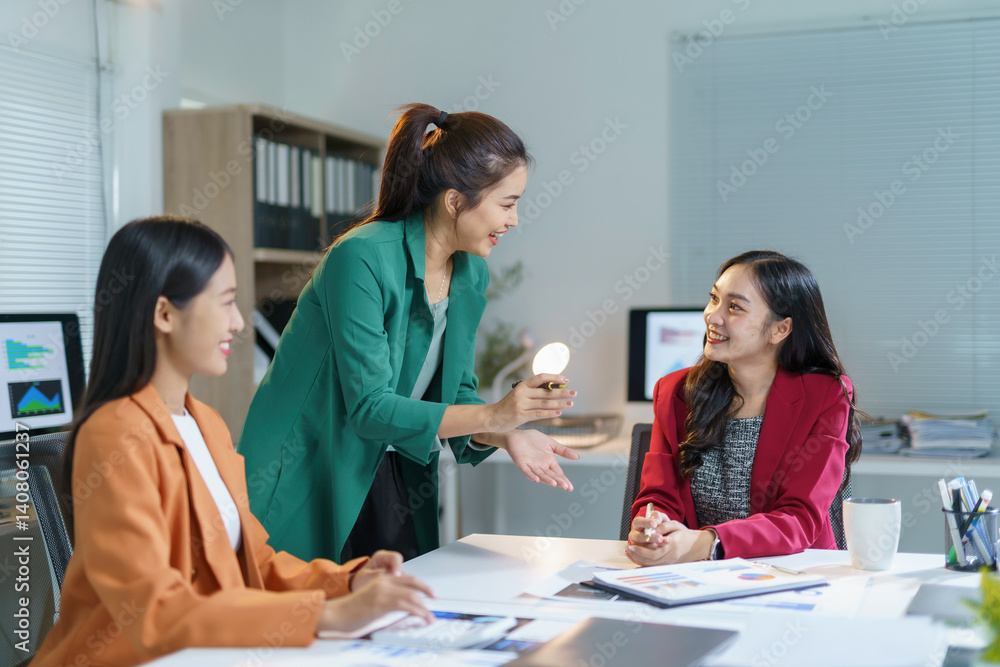 Obraz premium Three businesswomen engaging in a lively discussion about a project during a meeting in a stylish, modern office setting