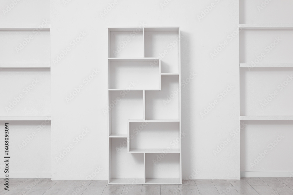 Fototapeta premium Empty shelving unit near light wall indoors