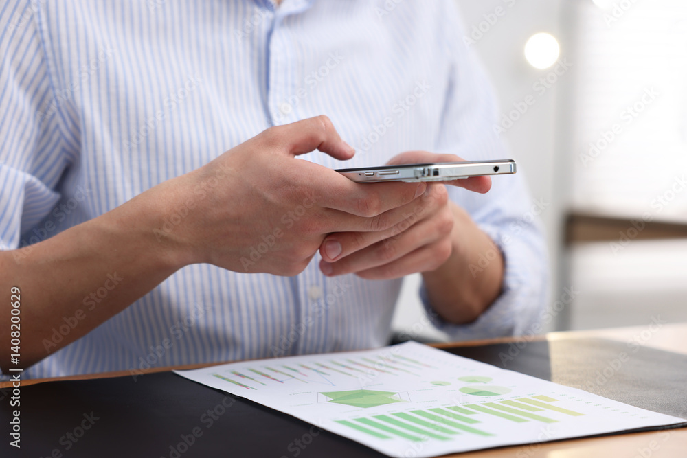 Man taking photo of document using scanning app on smartphone at desk in office, closeup