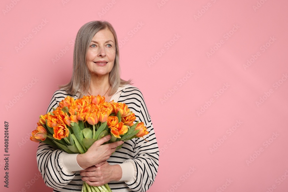 Smiling woman with bouquet of tulips on pink background. Space for text Smiling woman with bouquet of tulips on pink background. Space for text