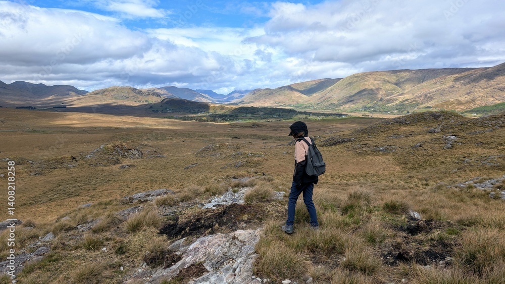 Young woman hiker backpacker hiking at Lackavrea mountain at Maum, Connemara national park, Galway, Ireland, nature adventure background