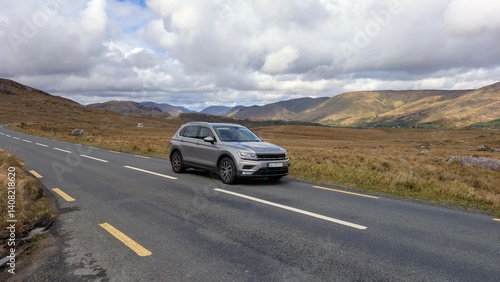 Beautiful landscape scenery with car driving on empty scenic road trough nature and mountains at Lackavrea, Maum, County Galway, Ireland Connemara national park	